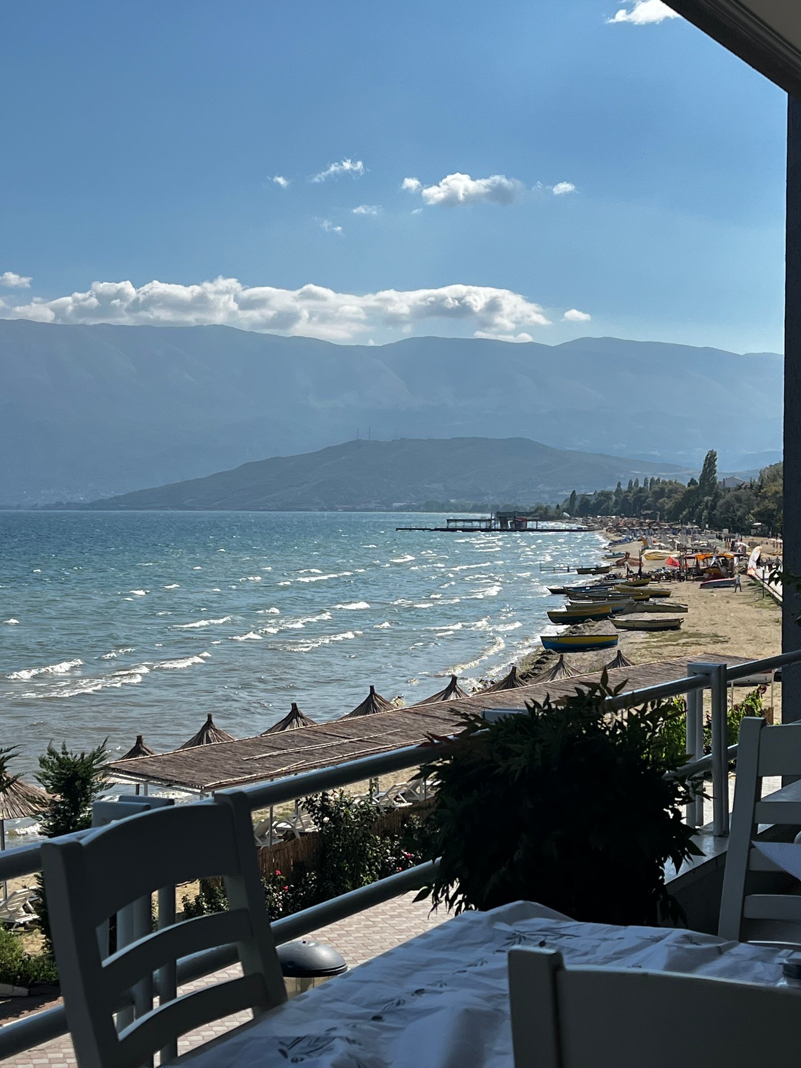 Lakeside cafe and beach on Lake Ohrid near Pogradec, with mountain backdrop